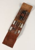 A TRAVELLING BOUSN KNIFE AND TOOLS in a leather folding case