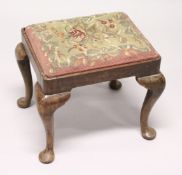 A GEORGIAN STOOL with needlework top on cabriole legs 1ft 7ins wide.