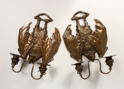 AN UNUSUAL PAIR OF CAST BRONZE BAT SHAPED TWIN LIGHT WALL SCONSES.