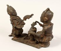 A TRIBAL BRONZE GROUP POSSIBLY, BENIN, two figures, one holding a turtle,the other a knife 10ins