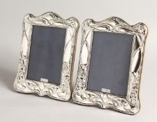 A PAIR OF SILVER ART NOUVEAU STYLE PHOTOGRAPH FRAMES. 8ins x 5.5ins