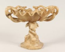 A 19TH CENTURY CARVED ALABASTER TAZZA with serpent handles and dolphin base. 10ins high.