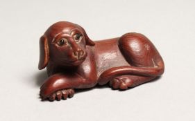 A JAPANESE CARVED WOOD DOG NETSUKE.