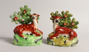 A PAIR OF STAFFORDSHIRE BOCAGE GROUPS OF RED DEER with yellow spots and Bocage backs 4.5ins high.