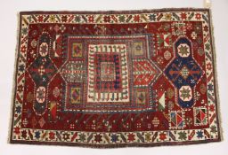 AN UNUSUAL SMALL CAUSASIAN SHIRWAN RUG, claret ground with stylised design. 4ft 2ins x 2ft 10ins