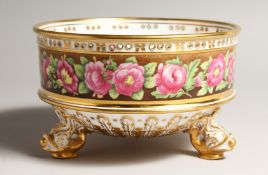 A GOOD CIRCULAR BOWL painted with a band of roses, on three dolphin feet. 6.5ins diameter.