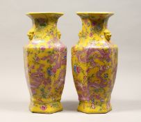 A PAIR OF CHINESE PORCELAIN HEXAGONAL SHAPE VASES, yellow ground, painted with dragons 17ins high