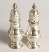 A PAIR OF PLAIN SILVER BALLISTER SHAPED PEPPERETTES. London, 1913 4.25ins high.