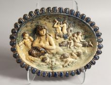 A 17TH - 18TH CENTURY MAJOLICA OVAL DISH with blue border, the centre with cupids and dolphins.