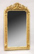 A LARGE ORNATE GILT FRAMED ARCH TOP MIRROR, the top with cherubs holding a basket of flowers 5ft