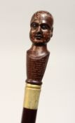 A NOVELTY WALKING STICK, the handle as a phrenology head 36ins high.