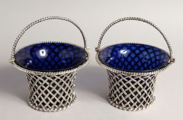 A VERY GOOD PAIR OF VICTORIAN PIERCED CIRCULAR BASKETS with swing handles and sapphire blue liners