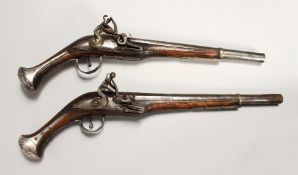 A NEAR PAIR OF EARLY FLINTLOCK PISTOLS with 12 inch engraved barrels, mahogany stock with silver.