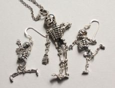 A PAIR OF SILVER ARTICULATED SKELETON EAR RINGS AND NECKLACE on a chain.