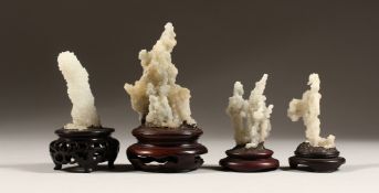 FOUR SMALL CORAL SPECIMENS on a wooden base.