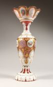 A TALL BOHEMIAN WHITE OVERLAY RED VASE with decoration painted with flowers. 15ins high.