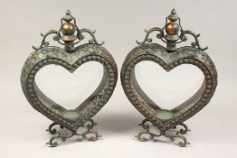 A PAIR OF HEART SHAPED GREEN PATENATED AND COPPER COLOURED HANGING LANTERNS. 21in high.