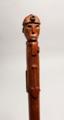 A COAL MINERS WOODEN WALKING CANE, the handle as a miner with Tilly lamps and shovel 35ins long.