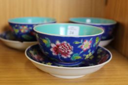 A set of three Chinese bowls with matching stands.