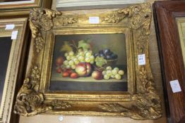 A still life of fruit on a ledge, oil on board, in a decorative gilt frame.