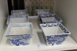 Six oriental blue and white square shaped dishes.