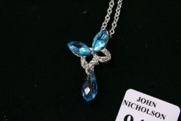 A decorative modern pendant and silver chain.