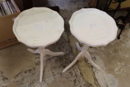 A pair of white painted tripod tables.