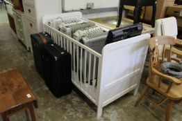 A white painted cot and a travel cot.