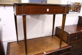 A mahogany side table with rising top enclosing a compartmented interior.