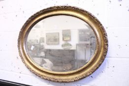 A gilt framed oval wall mirror.