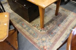 A Chinese carpet, beige ground with floral decoration.