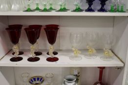 A set of six ruby glass wine glasses, the stems modelled as sea horses, together with three ribbed
