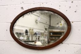 An oval wall mirror.