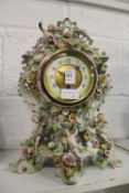 A continental mantle clock, the porcelain body with floral encrusted and cherub decoration.