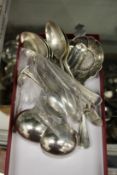 A set of four silver sauce ladles and various other silver spoons.