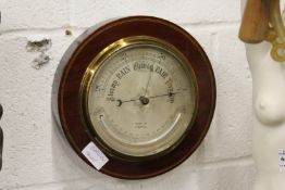 A mahogany cased circular barometer and thermometer.