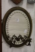 An oval mirror backed girandole.
