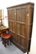 An oak linen fold decorated two door wardrobe.