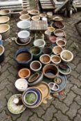 A large quantity of small garden pots and pot stands etc.