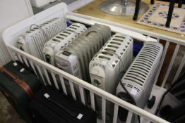 Five various oil filled electric portable heaters.