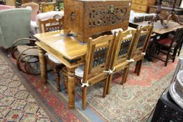 An Indonesian hardwood rectangular dining table with six chairs, each with wrought iron back