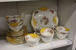 A Paragon part tea service decorated with yellow panels and exotic birds.
