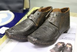 A pair of early children's leather and wood shoes, or miniature boots.