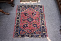 A small early 20th century Persian rug, pink ground with stylized decoration.