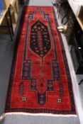 A red ground Persian woollen runner.