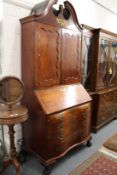 A good George III period mahogany cupboard bookcase, probably Philadelphia, with broken arch