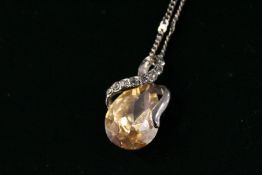 A decorative modern pendant and silver chain.