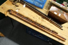 Two Chinese carved bamboo walking sticks and another bamboo stick.