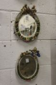A pair of continental floral encrusted oval porcelain mirrors.