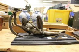 A reclining female nude, a bronze sculpture on a marble base.